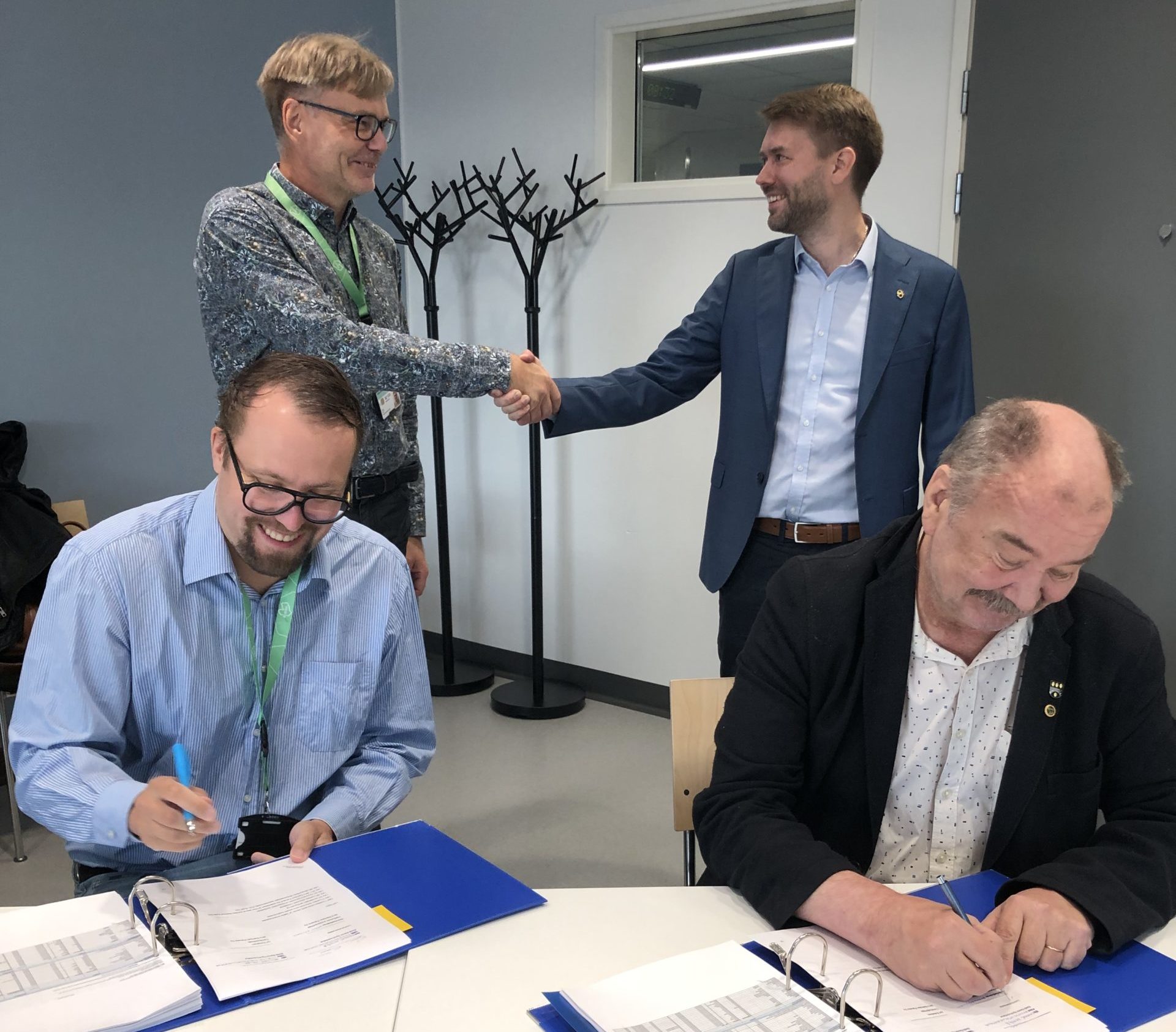 Kuvassa allekirjoittamassa Santeri Seppälä (vasemmalla) ja Hannu Auvinen. Takana kättelevät Velimatti Thure (vasemmalla) ja Jyri Eskelinen.